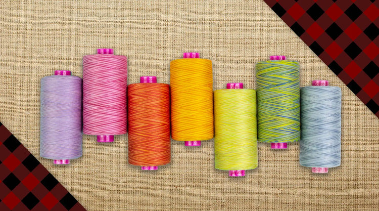 Eight spools of colorful sewing thread.